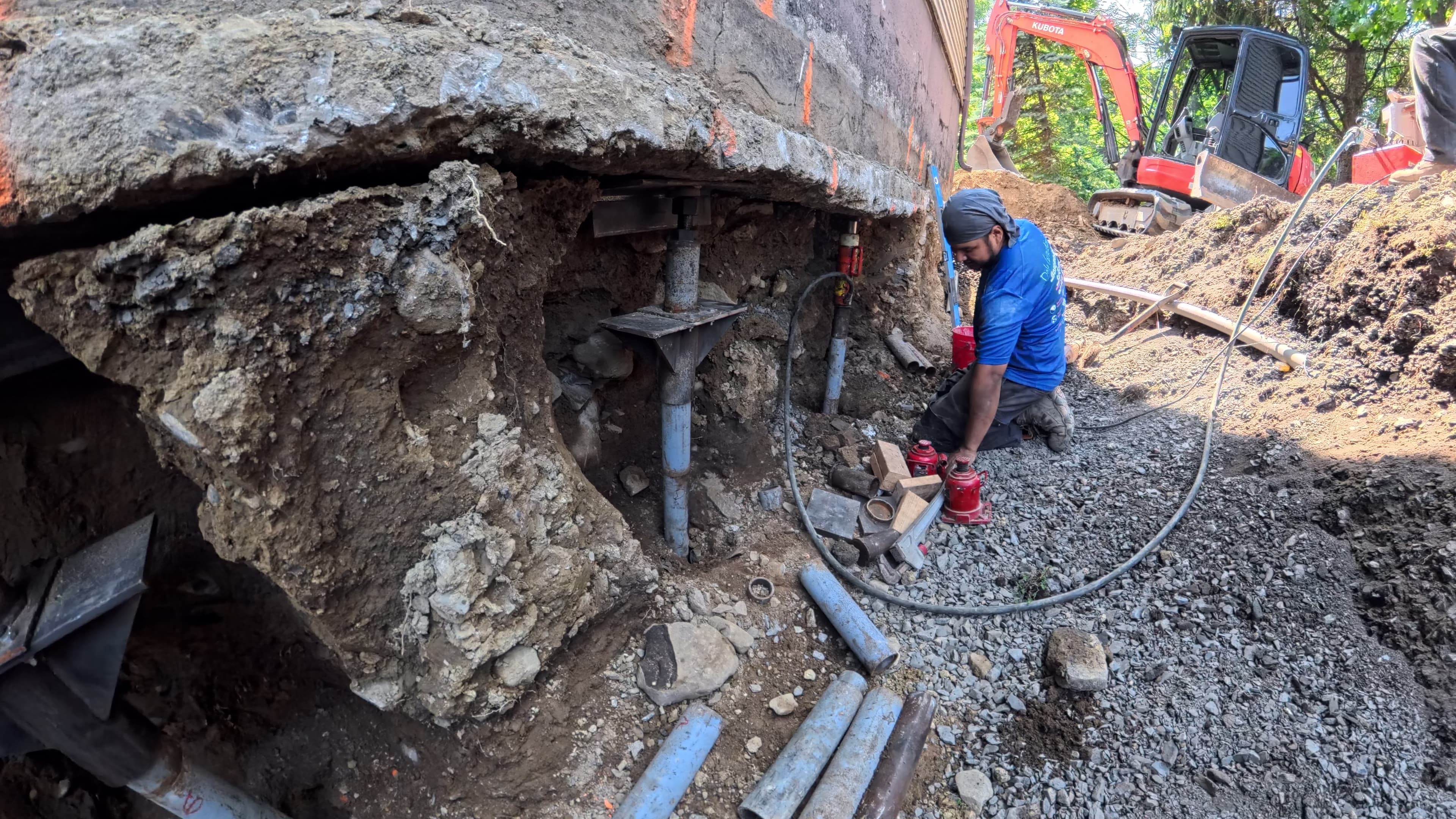 Hydraulic installation of Stabil-Loc push piers under the garage foundation in Washingtonville, NY