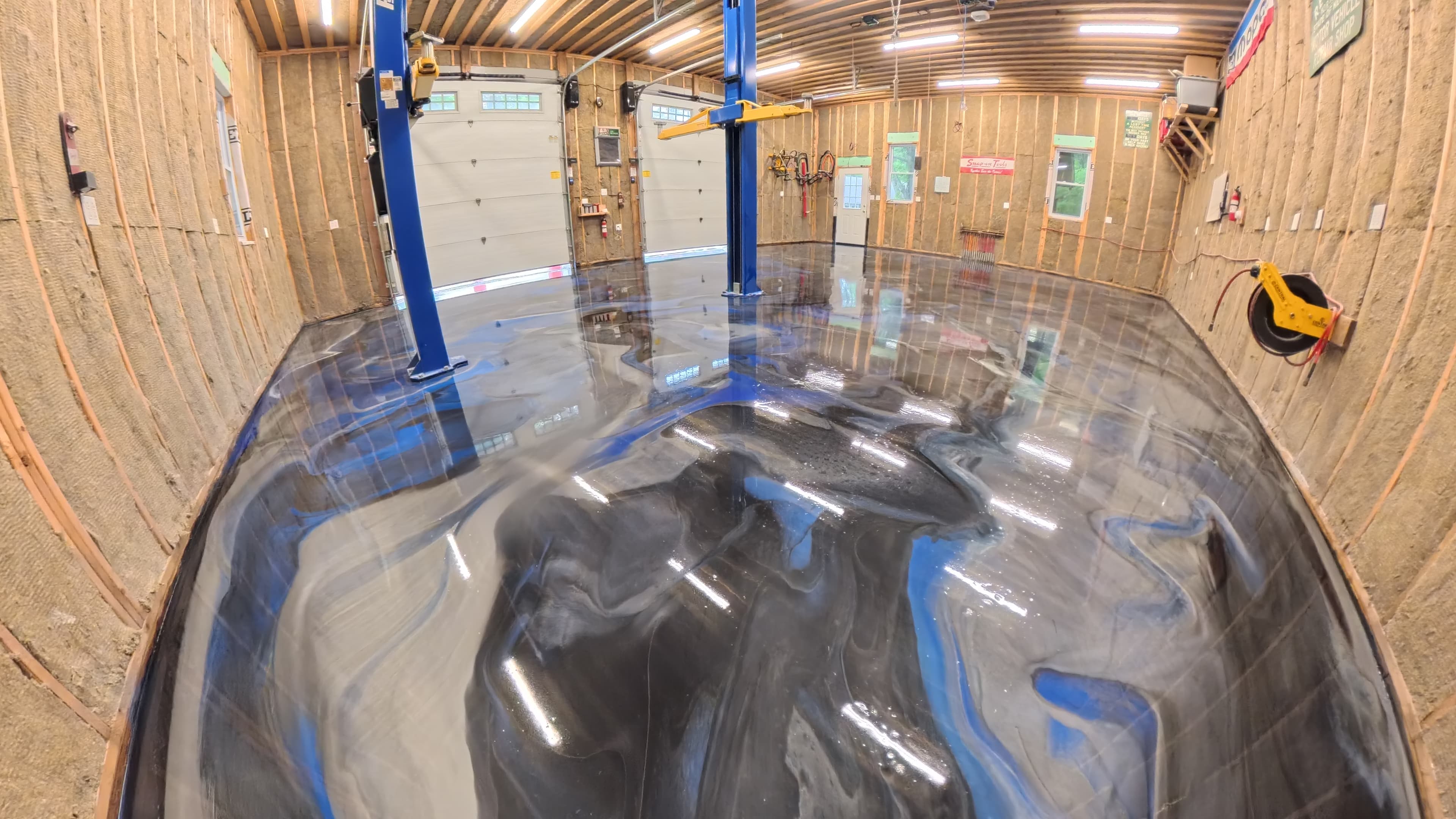 Finished blue, black, and silver waterfall epoxy floor in a mechanic's shop in Kerhonkson, NY